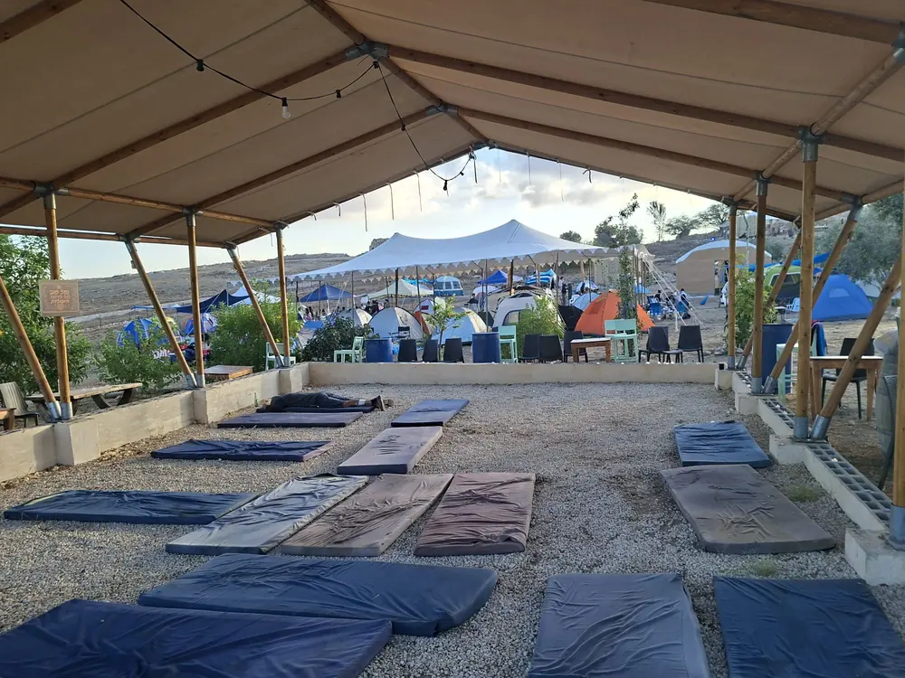 האוהל המרכזי עם מזרונים, ובמרחק אוהלי הקמפינג